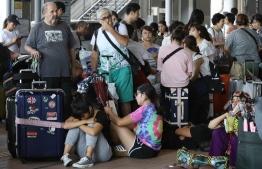 Passengers stranded overnight at the Kansai International Airport due to typhoon Jebi wait for transport out of the airport in Izumisano city, Osaka prefecture on September 5, 2018.
Japan scrambled to evacuate passengers trapped at a major airport when a tanker slammed into its only access bridge during the most powerful typhoon to hit the country for 25 years. / AFP PHOTO / JIJI PRESS / JIJI PRESS / 
