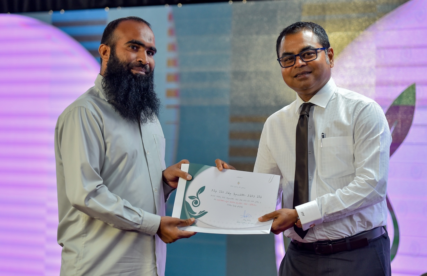 ޒަކާތު ފަންޑުގެ އެހީގައި ދޭ ސްކޮލަޝިޕްގެ ލިޔުން ހަވާލުކުރަން ބޭއްވި ހާއްސަ ރަސްމިއްޔާތުގައި ސްކޮލަޝިޕް ލިބުނު ދަރިވަރަކަށް، އެންވަޔަރްމަންޓް މިނިސްޓަރު ތޯރިގު (ކ) ލިޔުން ހަވާލުކޮށްދެއްވަނީ.-- ފޮޓޯ: އަހުމަދު ނިޝާތު /މިހާރު