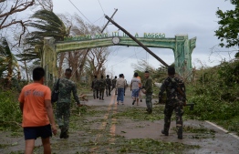Rescue workers clear a road of debris and toppled electric posts caused by strong winds due to super Typhoon Mangkhut as they try to reach Baggao town in Cagayan province, north of Manila September 15, 2018.
Super Typhoon Mangkhut slammed into the northern Philippines, with violent winds and torrential rains, as authorities warned millions in its path of potentially heavy destruction. / AFP PHOTO / TED ALJIBE