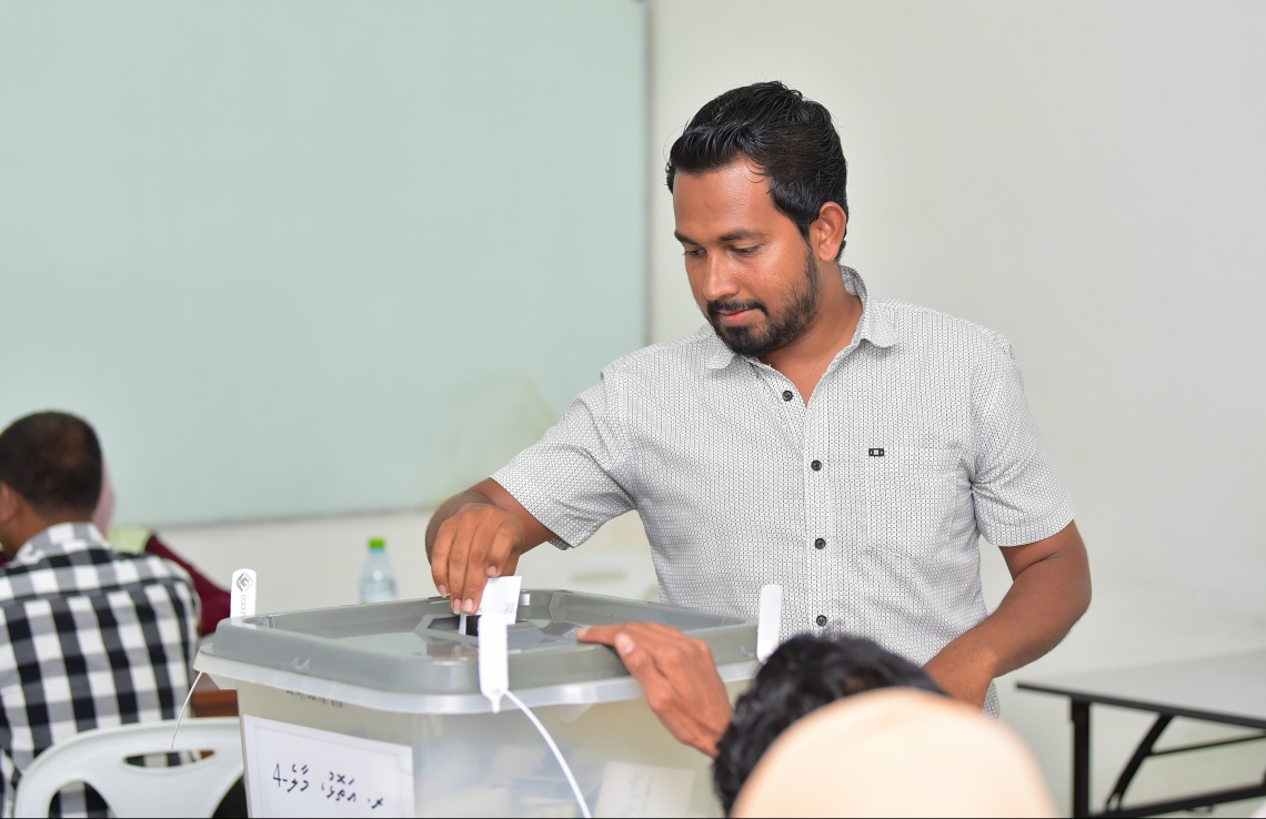 މާލެ: ސެޕްޓެމްބަރު 23، 2018: ރިޔާސީ އިންތިހާބުގެ ވޯޓުލުން: ޤުރުއާނާ ބެހޭ މަރުކަޒުގައި ބަހައްޓާފައިހުރި ރ.އަތޮޅުގެ ވޯޓު ފޮއްޓަކަށް މީހަކު ވޯޓުލަނީ.--ފޮޓޯ: ހުސައިން ވަހީދު/މިހާރު