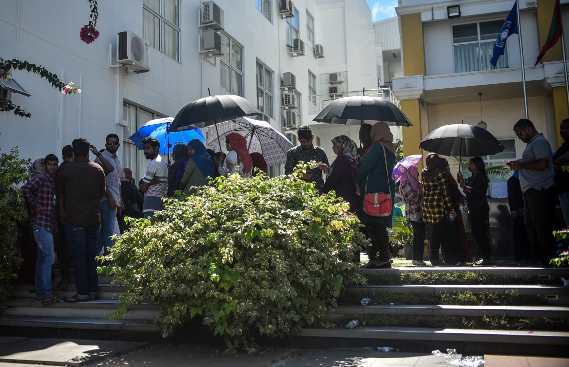 މާލެ: ސެޕްޓެމްބަރު 23، 2018: ރިޔާސީ އިންތިހާބުގެ ވޯޓުލުން: އެމްއެންޔޫ މައި އިމާރާތުގައި ބަހައްޓާފައި ހުރި ވޯޓު ފޮށިތަކަށް ވޯޓުލުމަށް މީހުން ކިޔޫ ހަދައިގެންތިބި އިރު ބައެއް މީހުން ކުޑަ އަޅައިގެން .--ފޮޓޯ: އަހުމަދު ނިޝާތު/މިހާރު