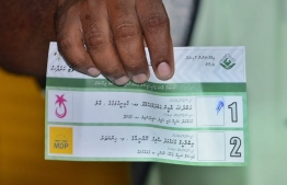 An election official shows a ballot paper during vote counting in the September 23rd Presidential Election. PHOTO/MIHAARU
