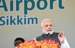 FILE PHOTO: This handout photo released by India's Press Information Bureau and taken on September 24, 2018, shows Indian Prime Minister Narendra Modi (R) addressing a gathering at the inauguration of the Pakyong Airport in Gangtok. / AFP PHOTO / PIB / Handout / 