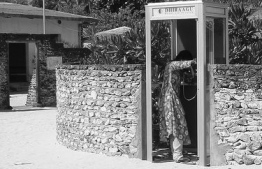 A woman pictured inside a telephone booth established by Dhiraagu in an island. PHOTO/DHIRAAGU