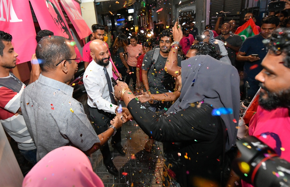 މާލެ: ސެޕްޓެމްބަރު 30، 2018- ޝަހްސު އޮޅުވާލުމުގެ ދައުވާއެއް ސާބިތުވެ، ހަތަރު މަހާއި 24 ދުވަހުގެ ޖަލު ހުކުމެއް ތަންފީޒު ކުރަމުންދިޔަ ދިއްގަރު ދާއިރާގެ މެމްބަރު އަދި މައުމޫންގެ ދަރިކަލުން އަހުމަދު ފާރިސް މައުމޫން ކަފާލާތުގެ ދަށުން ބަންދުން މިނިވަންވެ ވަޑައިގަތުމަށްފަހު، އެންދެރިމާގެއަށް ވަޑައިގަތުމުން މަރުހަބާ ދެންނެވުމުގެ ގޮތުން އެސަރަހައްދަށް އެއްވެ ތިބި މީހުންނާ ސަލާމް ކުރައްވަނީ.---ފޮޓޯ: ހުސައިން ވަހީދު/މިހާރު