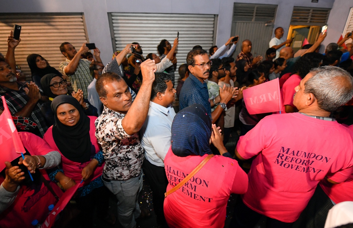 މާލެ: ސެޕްޓެމްބަރު 30، 2018- ގާނޫނާ ޚިލާފަށް ވެރިކަން ވައްޓާލަން އުޅުނު ކަމުގެ ތުހުމަތުގައި ހައްޔަރުކުރުމަށްފަހު މާފުށީ ޖަލުގައި ހުކުމް ތަންފީޒު ކުރައްވަމުން ގެންދެވި ކުރީގެ ރައީސް މައުމޫން އަބްދުލްގައްޔޫމް ކަފާލާތުގެ ދަށުން މިނިވަންވެ ވަޑައިގަތުމަށްފަހު އެންދެރިމާގެއަށް ވަޑައިގަތުމުން ގިނަ އަދަދެއްގެ މީހުން އެސަރަހައްދަށް އެއްވެ އެމަނިކުފާނަށް މަރުހަބާ ދަންނަވަނީ---ފޮޓޯ: ހުސައިން ވަހީދު/މިހާރު