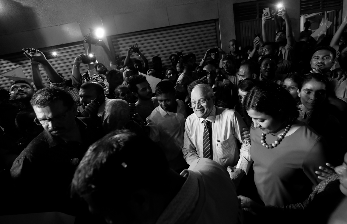 މާލެ: ސެޕްޓެމްބަރު 30، 2018- ގާނޫނާ ޚިލާފަށް ވެރިކަން ވައްޓާލަން އުޅުނު ކަމުގެ ތުހުމަތުގައި ހައްޔަރުކުރުމަށްފަހު މާފުށީ ޖަލުގައި ހުކުމް ތަންފީޒު ކުރައްވަމުން ގެންދެވި ކުރީގެ ރައީސް މައުމޫން އަބްދުލްގައްޔޫމް ކަފާލާތުގެ ދަށުން މިނިވަންވެ ވަޑައިގަތުމަށްފަހު އެންދެރިމާގެއަށް ވަޑައިގަތުމުން ގިނަ އަދަދެއްގެ މީހުން އެސަރަހައްދަށް އެއްވެ އެމަނިކުފާނަށް މަރުހަބާ ދަންނަވަނީ---ފޮޓޯ: ހުސައިން ވަހީދު/މިހާރު