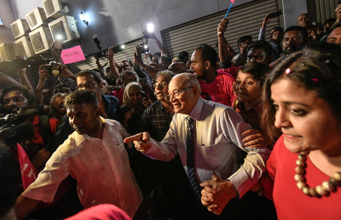 މާލެ: ސެޕްޓެމްބަރު 30، 2018- ގާނޫނާ ޚިލާފަށް ވެރިކަން ވައްޓާލަން އުޅުނު ކަމުގެ ތުހުމަތުގައި ހައްޔަރުކުރުމަށްފަހު މާފުށީ ޖަލުގައި ހުކުމް ތަންފީޒު ކުރައްވަމުން ގެންދެވި ކުރީގެ ރައީސް މައުމޫން އަބްދުލްގައްޔޫމް ކަފާލާތުގެ ދަށުން މިނިވަންވެ ވަޑައިގަތުމަށްފަހު އެންދެރިމާގެއަށް ވަޑައިގަތުމުން ގިނަ އަދަދެއްގެ މީހުން އެސަރަހައްދަށް އެއްވެ އެމަނިކުފާނަށް މަރުހަބާ ދަންނަވަނީ---ފޮޓޯ: ހުސައިން ވަހީދު/މިހާރު