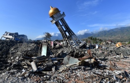 The minaret of a mosque rests to one side amongst the devastation in the hard-hit area of Balaroa in Palu on October 8, 2018, following the September 28 earthquake and tsunami.
Nearly 2000 bodies have been recovered from Palu since an earthquake and tsunami struck the Indonesian city, an official said on October 8, warning the number would rise with thousands still missing. / AFP PHOTO / ADEK BERRY