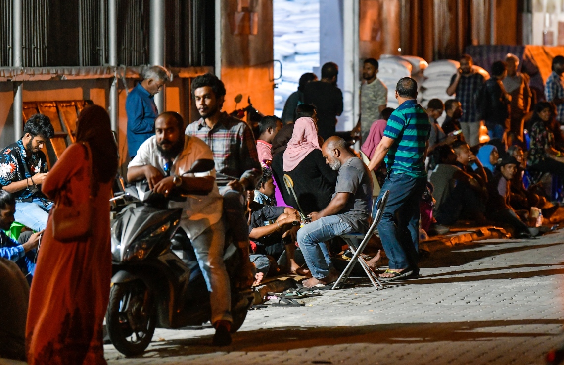 މާލެ: އޮކްޓޯބަރު 10، 2018: ހުޅުމާލޭގެ ދެ ވަނަ ފިޔަވަހިން 400 ގޯތި ގަންނަން ބޭނުންވާ މީހުންނަށް އެ ފުރުސަތު ހުޅުވާލުމާ އެކު، ހައުސިން މިނިސްޓްރީ ކައިރީގައި ދަމާލި ކިޔޫ ދިގުދެމިގެން އައިސް މިއަދު ދޫކުރި 500 ނަމްބަރު ހުސްވުމުން، މާދަމާ ދޫކުރާ 500 ނަމްބަރުގައި ލައްވާލާތޯ މިރޭގެ ނިދި ނަގާލުމަށްފަހު ގިނައަދަދެއްގެ މީހުން ހައުސިން މިނިސްޓްރީ ހުންނަ އިމާރާތާ ޖެހިގެން ހުންނަ އެސްޓީއޯ ގުދަންތައް ކައިރި މާދަމާގެ ކިޔޫގައި މަޑުކޮށްގެން،---ފޮޓޯ: ހުސައިން ވަހީދު/މިހާރު