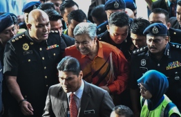 Detained Malaysia's deputy former prime minister Ahmad Zahid Hamidi is escorted by police to a court in Kuala Lumpur to face charges on October 19, 2018. - Malaysia's opposition leader, Ahmad Zahid was arrested on October 18 on suspicion of corruption, a fresh blow to his party United Malays National Organisation (UMNO), which was ousted at elections this year after six decades in power. (Photo by - / AFP) /