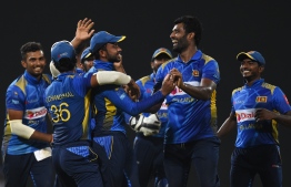 Sri Lankan cricketer Sadeera Samarawickrama (C) celebrates with teammates after he dismissed England cricketer Jos Buttlerduring the fifth and final one day international (ODI) cricket match between Sri Lanka and England at the R. Peremadasa Stadium in Colombo on October 23, 2018. (Photo by AFP)