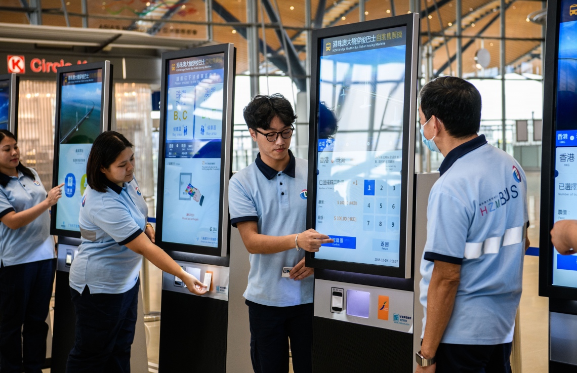 ހޮންކޮން-ޒުހައި-މަކާއޫ ބްރިޖުގެ ހޮންކޮން ޑިޕާޗާ ހޯލުން ޓިކެޓް ގަންނާނެ ގޮތް ސްޓާފުން ދައްކާލަދެނީ. --ފޮޓޯ:އޭއެފްޕީ