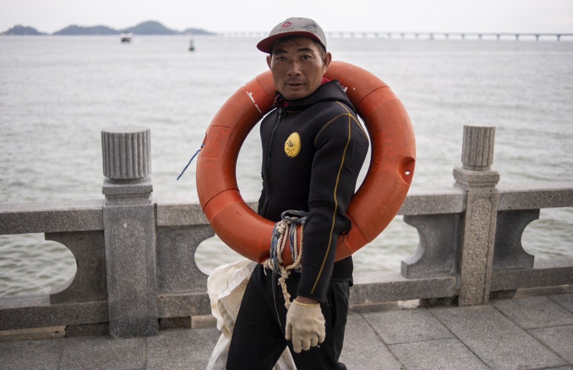 ހޮންކޮން-ޒުހައި-މަކާއޫ ބްރިޖް ކައިރިން މަސްވެރިއަކު ދަނީ. --ފޮޓޯ:އޭއެފްޕީ