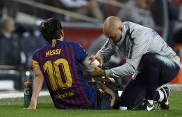 Barcelona's Argentinian forward Lionel Messi receives medical assistance during the Spanish league football match FC Barcelona against Sevilla FC at the Camp Nou stadium in Barcelona on October 20, 2018. 
LLUIS GENE / AFP