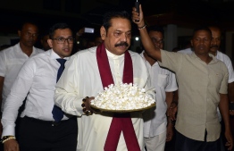 Sri Lanka's former president and new prime minister Mahinda Rajapakse arrives at a temple after having been sworn in as prime minister in Colombo on October 26, 2018. - Sri Lankan President Sirisena on October 26 sacked his Prime Minister Ranil Wickremesinghe and appointed former president Mahinda Rajapakse as the new premier, the president's office said. (Photo by LAKRUWAN WANNIARACHCHI / AFP)