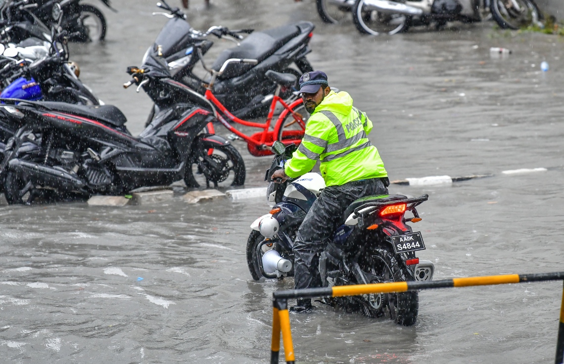 މާލެ: އޮކްޓޯބަރު 28، 2018- މާލެ އަށް މިއަދު ހެނދުނުއްސުރެ ފެށިގެން ވެހެމުންދާ ބޯ ވާރޭގައި ފެން ބޮޑުވެފައިވާ މަގެއްގައި ޓްރެފިކް ޕޮލިހަކު ސައިކަލްގައި ދަނީ: މާލޭގެ ބައެއް މަގުތަކުގައި މިއަދު ވަނީ އާދަޔާ ޚިލާފަށް ފެން ބޮޑުވެ، ހިނގައިބިނގައި އުޅުމަށް ބޮޑެތި ދަތިތަކެއް ކުރިމަތިވެފައި.---ފޮޓޯ: ނިޝާން އަލީ/މިހާރު