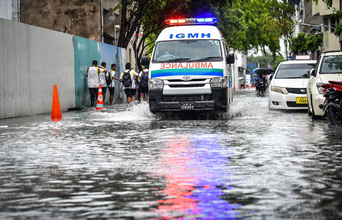 މާލެ: އޮކްޓޯބަރު 28، 2018- މާލެ އަށް މިއަދު ހެނދުނުއްސުރެ ފެށިގެން ވެހެމުންދާ ބޯ ވާރެއާ ގުޅިގެން، ފެން ބޮޑުވެފައިވާ މަގެއްގައި އައިޖީއެމްއެޗުގެ އެންބިއުލާންސެއް ދުއްވާފައި ދަނީ: މާލޭގެ ބައެއް މަގުތަކުގައި މިއަދު ވަނީ އާދަޔާ ޚިލާފަށް ފެން ބޮޑުވެ، ހިނގައިބިނގައި އުޅުމަށް ބޮޑެތި ދަތިތަކެއް ކުރިމަތިވެފައި.---ފޮޓޯ: ނިޝާން އަލީ/މިހާރު