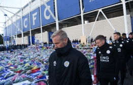 Leicester City's Danish goalkeeper Kasper Schmeichel (L) and Leicester City's English striker Jamie Vardy (2nd L) look at the floral tributes left to the victims of the helicopter crash which killed Leicester City's Thai chairman Vichai Srivaddhanaprabha, outside Leicester City Football Club's King Power Stadium in Leicester, eastern England, on October 29, 2018.
Paul ELLIS / AFP