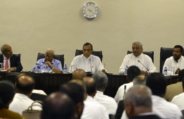 FILE PHOTO: Sri Lanka's parliament speaker Karu Jayasuriya (C) looks on at a meeting of MPs at the Parliament Building in Colombo on November 2, 2018. - Sri Lanka's speaker on November 2 summoned the country's parliament to meet next week in defiance of the president as a constitutional crisis darkened with an MP telling how he was offered millions of dollars and a minister's post to defect to a rival camp. (Photo by LAKRUWAN WANNIARACHCHI / AFP)