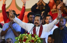 Sri Lanka's former president and new prime minister Mahinda Rajapakse waves to his supporters at a rally in Colombo on November 5, 2018. - Thousands of supporters of former Sri Lankan president Mahinda Rajapakse headed for the capital on November 5 to rally in support of his controversial nomination as prime minister, as the island's constitutional crisis deepened. (Photo by LAKRUWAN WANNIARACHCHI / AFP)