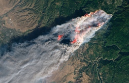This NASA Earth Observatory handout image taken on November 8, 2018 and released on November 10, 2018 shows the Camp Fire burning in Paradise, California. - The death toll from the most destructive fire to hit California rose to 23 on November 10 as rescue workers recovered more bodies of people killed by the devastating blaze. Ten of the bodies were found in the town of Paradise while four were discovered in the Concow area, both in Butte County, Honea said. (Photo by Joshua Stevens / NASA Earth Observatory / AFP) / 