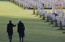 British Prime Minister Theresa May (R) and French President Emmanuel Macron walk near graves at the World War I French-British memorial of Thiepval, northern France, on November 9, 2018, during a ceremony marking the 100th anniversary of the end of the WWI. - The memorial commemorates more than 72,000 men of British and South African forces who died in the Somme sector before 20 March 1918 and have no known grave, the majority of whom died during the Somme offensive of 1916. (Photo by LUDOVIC MARIN / POOL / AFP)
