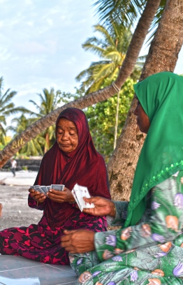 Ladies of L.Gan enjoy a round of cards at a 'holhuashi' by the harbour at sunset. PHOTO: HAWWA AMANY ABDULLA / THE EDITION