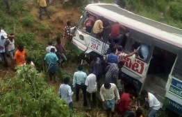 Onlookers and rescuers gather around a bus that crashed in Jagtial district in India's southern Telangana state on September 11, 2018. On November 24, 2018, police said they retrieved 28 bodies from a private passenger bus after it veered off the road and fell into the canal in the Mandya district. PHOTO | AFP