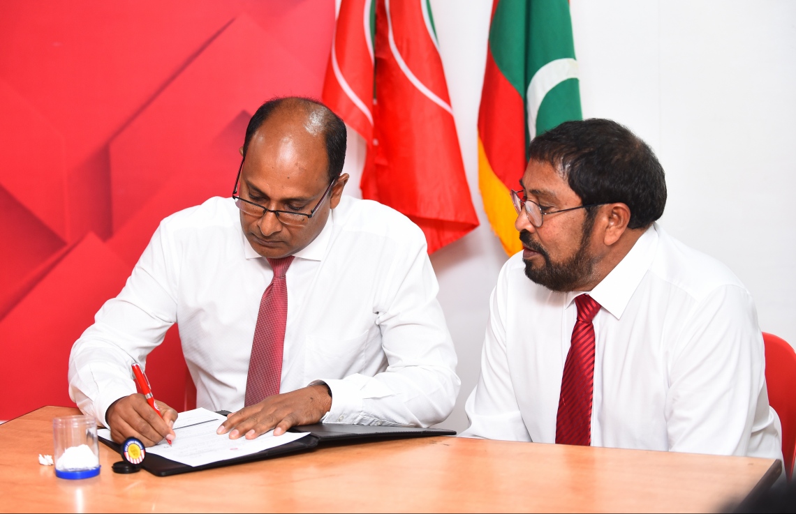 މާލެ: ނޮވެމްބަރު 25، 2018- ކުޑަކުދިންނަށް ޚާއްސަ ދީނީ ޕްރޮގްރާމް ހުށަހަޅުއްވާ އަބްދުއްލަތީފް އަހުމަދު ޖުމްހޫރީ ޕާޓީއަށް ސޮއިކުރައްވާއިރު، އެ ޕާޓީގެ ލީޑަރު ގާސިމް އެ ރަސްމިއްޔާތުގައި ބައިވެރިވެވަޑައިގަންނަވަނީ.---ފޮޓޯ: ހުސައިން ވަހީދު/މިހާރު