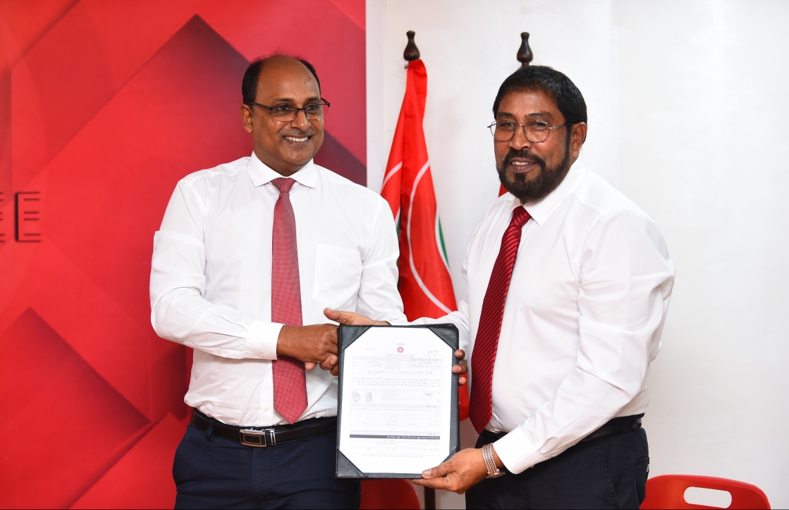 މާލެ: ނޮވެމްބަރު 25، 2018- ކުޑަކުދިންނަށް ޚާއްސަ ދީނީ ޕްރޮގްރާމް ހުށަހަޅުއްވާ އަބްދުއްލަތީފް އަހުމަދު ޖުމްހޫރީ ޕާޓީއަށް ސޮއިކުރެއްވުމަށް ފަހު، އޭނާގެ ފޯމު އެ ޕާޓީގެ ލީޑަރު ގާސިމްއާ ހަވާލުކުރައްވަނީ.---ފޮޓޯ: ހުސައިން ވަހީދު/މިހާރު