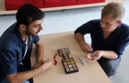 Iraqi artist Hoshmand Mofaq and British archaeologist Ashley Barlow (R) play an ancient board game, known as the Royal Game of Ur, in the northern Iraqi city of Raniey on October 22, 2018. - Originating nearly 5,000 years ago in what would become Iraq, the Royal Game of Ur mysteriously died out -- until Muwafaq resurrected it by making his own decorated wooden board. (Photo by SHWAN MOHAMMED / AFP)