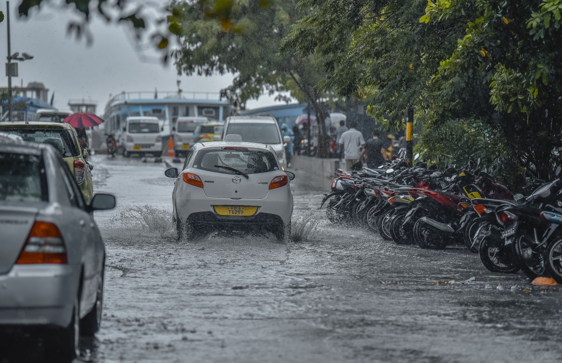 މާލެ: ނޮވެމްބަރު 29، 2018- މާލެއަށް މިއަދު ވެހުނު ބޯ ވާރޭގައި، މަގެއްގައި ފެންބޮޑުވެފައިވާއިރު ޓެކްސީއެއް އެ މަގުން ދުއްވާފައި ދަނީ.---ފޮޓޯ: އަހުމަދު ނިޝާތު/މިހާރު