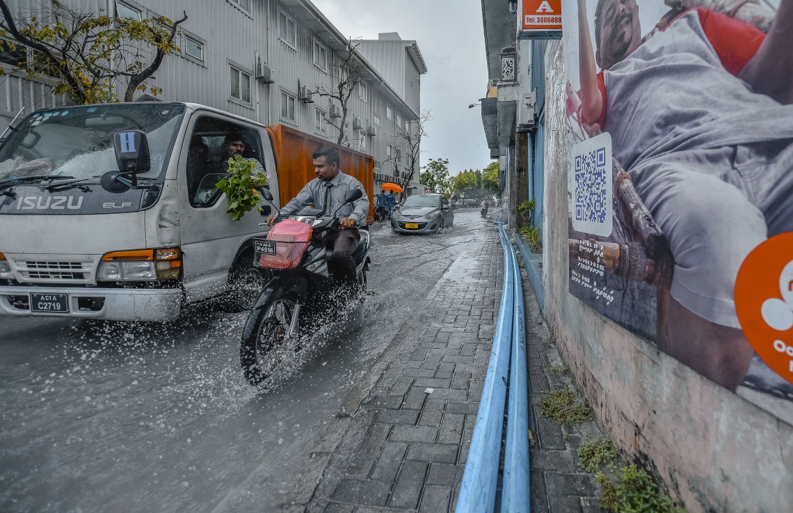 މާލެ: ނޮވެމްބަރ 29، 2018- މާލެއަށް މިއަދު ވެހުނު ބޯ ވާރޭގައި، މަގެއްގައި ފެންބޮޑުވެފައިވާއިރު މީހަކު ސައިކަލްގައި ދަނީ.---ފޮޓޯ: އަހުމަދު ނިޝާތު/މިހާރު