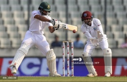 Bangladesh's Shadman Islam (L) plays a shot as West Indies's wicketkeeper Shane Dowrich watches during the first day of the second Test cricket match between Bangladesh and West Indies in Dhaka on November 30, 2018. PHOTO: AFP