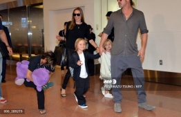 In this file photo taken on July 28, 2013 US film stars Brad Pitt (R) and Angelina Jolie (C), accompanied by their children, arrive at Haneda International Airport in Tokyo. PHOTO: AFP