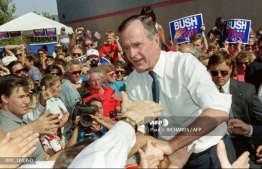 In this file photo taken on August 05, 1992 US President George Bush shakes hands with supporters upon his arrial in Reno. PHOTO: AFP