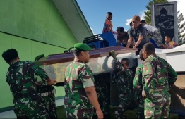 Indonesian soldiers prepare coffins for construction workers, believed to have been shot dead, in Wamena in Papua province on December 4, 2018. - Indonesia is investigating reports that 31 construction workers were shot dead by separatist rebels in restive Papua province, the public works minister said on December 4, as he halted construction in the area. (Photo by STAF STEEL / AFP)