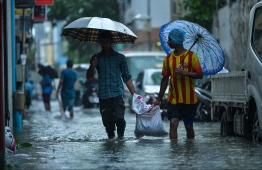 Expatriate workers on a flooded street in Male' on November 5. PHOTO: HUSSAIN WAHEED/MIHAARU