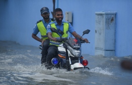 Traffic Police driving on a flooded street in Male' on November 5. PHOTO: AHMED NISHAATH/MIHAARU