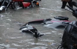 A motorcycle on its side on a flooded street in Male' on November 5. PHOTO: AHMED NISHAATH/MIHAARU
