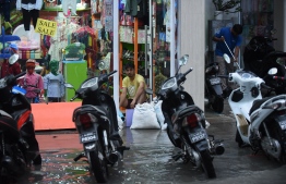 A man stacks sand bags to prevent flood water from entering a shop in Male City after heavy rains FILE PHOTO/MIHAARU