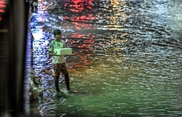 A young man on a flooded street in Male' on November 5. PHOTO: NISHAN ALI/MIHAARU