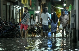 People walk on a flooded street in Male' on Wednesday. PHOTO: NISHAN ALI/MIHAARU