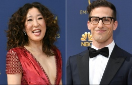 (COMBO) This combination of pictures created on December 05, 2018 shows actress Sandra Oh (L) and actor Andy Samberg (R) arriving for the 70th Emmy Awards at the Microsoft Theatre in Los Angeles, California on September 17, 2018. - The HFPA (Hollywood Foreign Press Association) has announced on December 5, 2018, actress Sandra Oh and actor Andy Samberg will be the 2019 Golden Globe ceremony hosts. (Photos by VALERIE MACON / AFP)