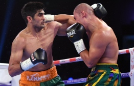 (FILES) In this file photo taken on August 5, 2017 Indian boxer and WBO Asia-Pacific Super Middleweight champion Vijender Singh (L) throws a punch at WBO Oriental Super Middleweight champion of China Zulpikar Maimaitiali during their double title bout at the National Sports Complex of India (NSCI) Dome in Mumbai. - Indian boxing superstar Vijender Singh is keen to trade punches with Mexico's Canelo Alvarez at Madison Square Garden after signing a new deal with the legendary US promoter Bob Arum. The 33-year-old Singh, a bronze medallist at the 2008 Beijing Olympics, has an unbeaten 10-0 record since he turned pro in 2015, but failed to get a single fight this year. (Photo by PUNIT PARANJPE / AFP)