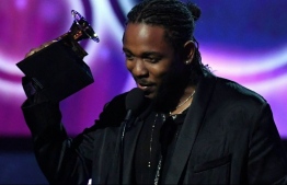 (FILES) In this file photo taken on January 28, 2018 Kendrick Lamar receives the Grammy for the Best Rap Album with DAMN. during the 60th Annual Grammy Awards show in New York. - The soundtrack of Marvel's "Black Panther" propelled rap superstar Kendrick Lamar to the front of 2018's Grammy pack with eight nominations, closely followed by fellow rapper Drake who scored seven. Women performers also achieved far greater presence in the 2019 edition of the top music awards, with Cardi B, Lady Gaga and folk-rock singer Brandi Carlile all nabbing nominations across the top categories. (Photo by Timothy A. CLARY / AFP)