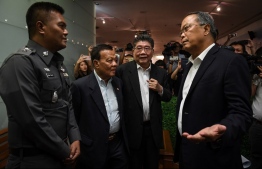 (FILES) This file photo taken on May 17, 2018 shows Pheu Thai party legal head Chusak Sirinul (R) speaking to a Thai police officer (L) during an attempt to stop the press conference as party officials, acting general secretary Phumtham Wechayachai (2nd-R) and Noppadol Patama (3rd-R) looks on at the party headquarters in Bangkok ahead of the fourth anniversary of the May 22, 2014 Thai military coup. - Thailand's junta has lifted a ban on political campaigning ahead of 2019 elections, an order published by the Royal Gazette said December 11, 2018, more than four years after it was introduced following the kingdom's latest coup. (Photo by Lillian SUWANRUMPHA / AFP)