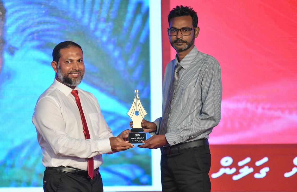 މާލެ: ޑިސެމްބަރު 11، 2018: ރާއްޖޭގެ ނޫސްވެރިކަމަށް 75 އަހަރު ފުރުމުގެ އަލިމަސްޔޫބީލް ފާހަގަ ކުރުމަށާއި ނޫސްވެރިކަމުގެ މިދިޔަ އަހަރުގެ އިނާމުތައް ދިނުމަށް މޯލްޑިވްސް މީޑިއާ ކައުންސިލާއި ހޯމް މިނިސްޓްރީ ގުޅިގެން ބޭއްވި ޖަލްސާގައި ނޫސްވެރިކަމުގެ ރަން ގަލަން ހާސިލްކުރެއްވި "މިހާރު"ގެ މެނޭޖިން އެޑިޓަރު އަދި "ދޯ" މަޖައްލާގެ އެޑިޓަރު އިސްމާއީލް ނަސީރުއަށް ހޯމް މިނިސްޓަރު ޝޭހް އިމްރާން އެވޯޑު ދެއްވަނީ.---ފޮޓޯ: އަހުމަދު ނިޝާތު/މިހާރު