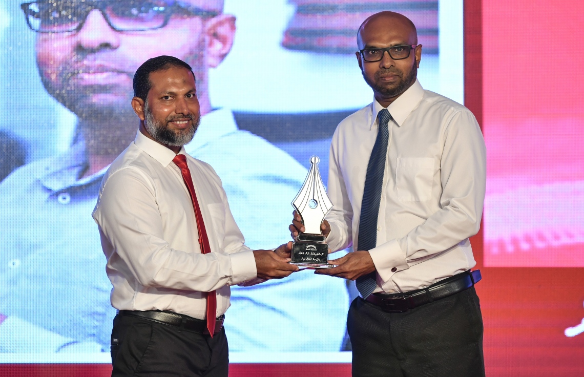 މާލެ: ޑިސެމްބަރު 11، 2018: ރާއްޖޭގެ ނޫސްވެރިކަމަށް 75 އަހަރު ފުރުމުގެ އަލިމަސްޔޫބީލް ފާހަގަ ކުރުމަށާއި ނޫސްވެރިކަމުގެ މިދިޔަ އަހަރުގެ އިނާމުތައް ދިނުމަށް މޯލްޑިވްސް މީޑިއާ ކައުންސިލާއި ހޯމް މިނިސްޓްރީ ގުޅިގެން ބޭއްވި ޖަލްސާގައި ނޫސްވެރިކަމުގެ ރަން ގަލަން ހާސިލްކުރެއްވި "މިހާރު"ގެ ސީނިއާ އެސިސްޓެންޓް އެޑިޓަރު ހަސަން އާމިރަށް ހޯމް މިނިސްޓަރު ޝޭހް އިމްރާން އެވޯޑު ދެއްވަނީ.---ފޮޓޯ: އަހުމަދު ނިޝާތު/މިހާރު